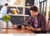 stock-photo-man-at-coffee-shop-using-digital-tablet-289833029.jpg